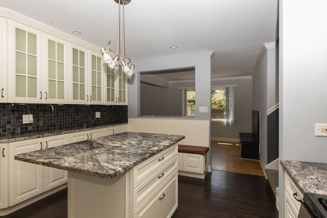 5940 W 88th Pl, Oak Lawn, IL 60453 - kitchen with glass insert cabinets, decorative backsplash, a kitchen island, dark wood-style flooring, and crown molding