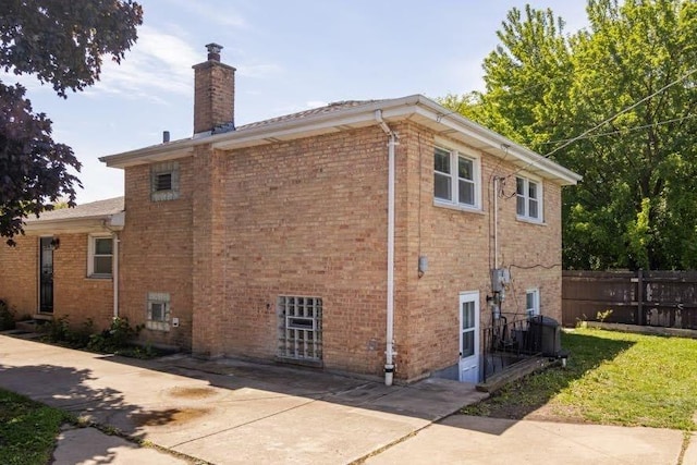 5940 W 88th Pl, Oak Lawn, IL 60453 - view of home's exterior featuring a chimney, brick siding, and a patio