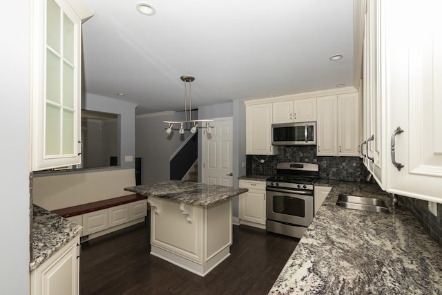 5940 W 88th Pl, Oak Lawn, IL 60453 - kitchen featuring appliances with stainless steel finishes, tasteful backsplash, dark wood-style floors, white cabinets, and dark stone counters
