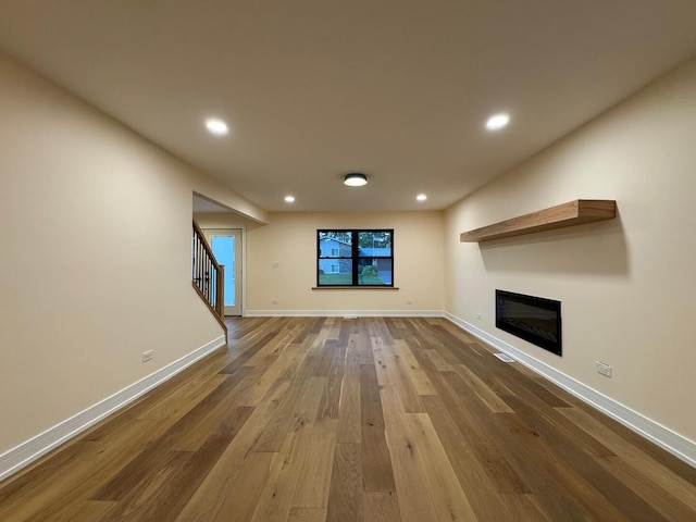 6013 Perry Dr, Woodridge, IL 60517 - unfurnished living room featuring wood finished floors, a glass covered fireplace, baseboards, recessed lighting, and stairway