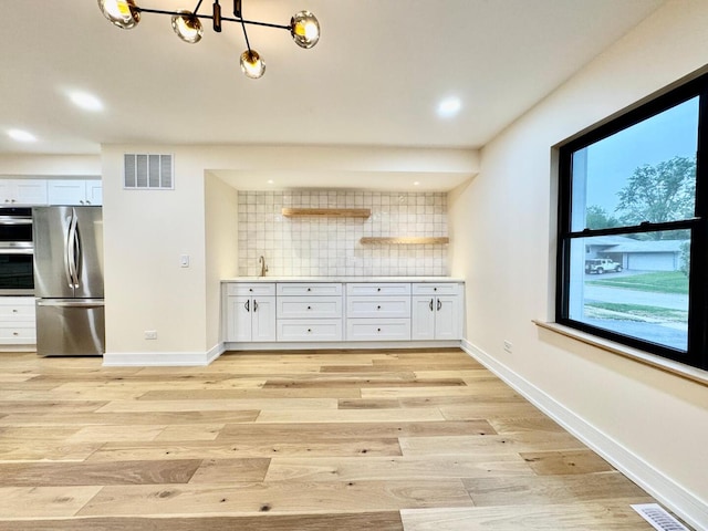 6013 Perry Dr, Woodridge, IL 60517 - kitchen featuring freestanding refrigerator, decorative backsplash, light wood-type flooring, baseboards, and recessed lighting