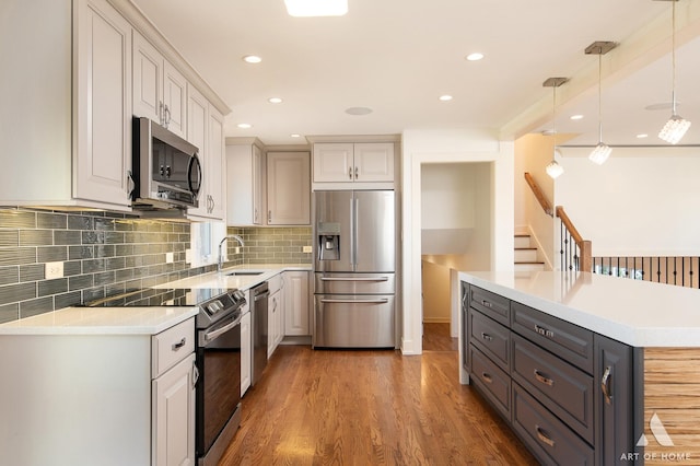 8519 S 82nd Ct, Hickory Hills, IL 60457 - kitchen with stainless steel appliances, light countertops, decorative light fixtures, wood finished floors, and tasteful backsplash