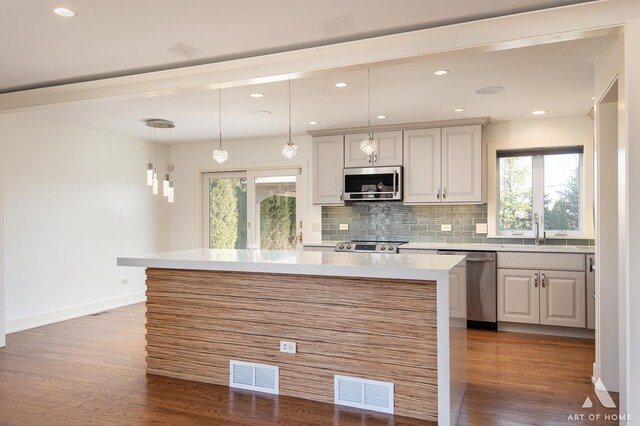 8519 S 82nd Ct, Hickory Hills, IL 60457 - kitchen with stainless steel appliances, wood finished floors, light countertops, decorative backsplash, and a center island