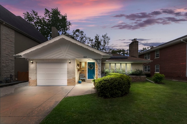 464 Northgate Ct, Riverside, IL 60546 - ranch-style home featuring concrete driveway, brick siding, roof mounted solar panels, an attached garage, and a yard