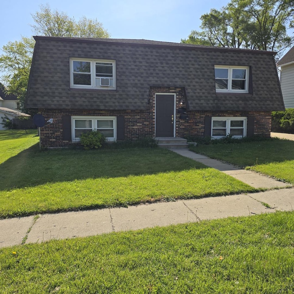 126 Sabin St, Sycamore, IL 60178 - view of front facade with brick siding and a shingled roof