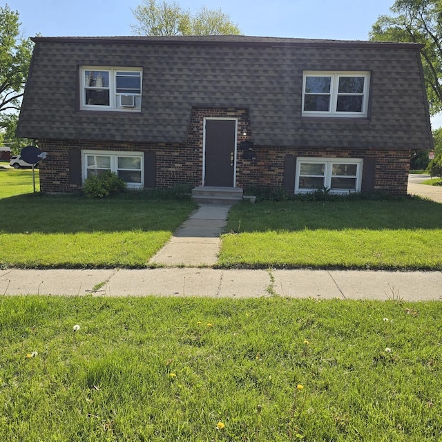126 Sabin St, Sycamore, IL 60178 - view of front facade with a shingled roof, brick siding, a front lawn, and mansard roof