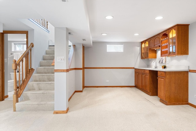 124 N W End Ave, Westmont, IL 60559 - kitchen featuring light carpet, baseboards, brown cabinets, glass insert cabinets, and recessed lighting