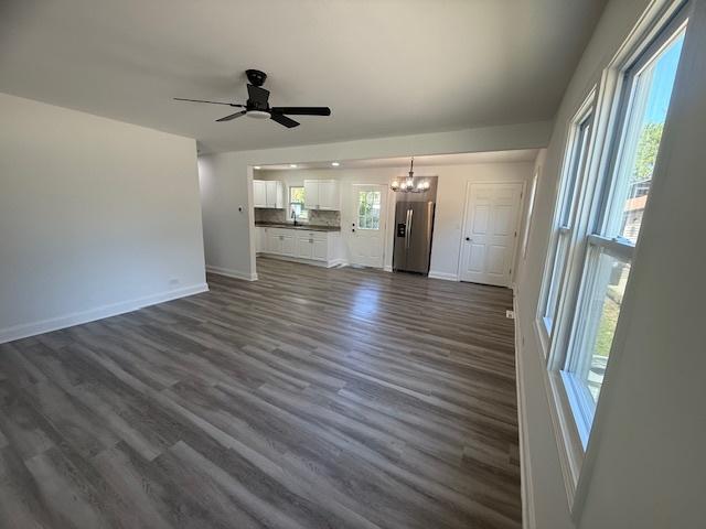 528 Ivy Ct, Round Lake Beach, IL 60073 - unfurnished living room featuring a chandelier, baseboards, ceiling fan, and dark wood finished floors