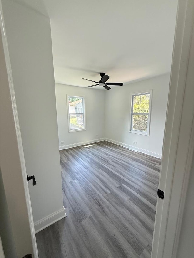 528 Ivy Ct, Round Lake Beach, IL 60073 - unfurnished room with plenty of natural light, baseboards, dark wood-style floors, and ceiling fan