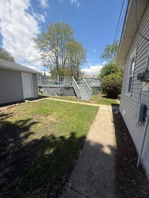 528 Ivy Ct, Round Lake Beach, IL 60073 - view of grassy yard featuring a deck and an outbuilding