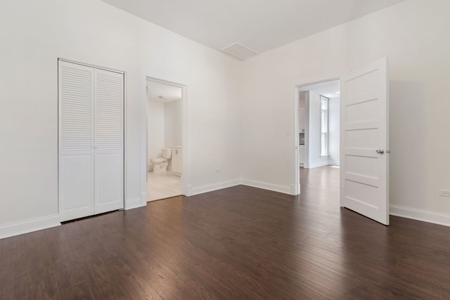 718 Sycamore St, Ottawa, IL 61350 - unfurnished bedroom with dark wood finished floors, baseboards, and connected bathroom
