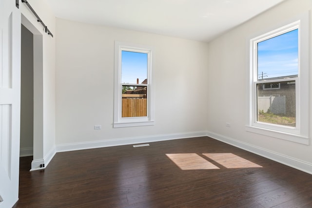 718 Sycamore St, Ottawa, IL 61350 - empty room with a barn door, dark wood finished floors, and baseboards