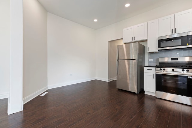 718 Sycamore St, Ottawa, IL 61350 - kitchen with appliances with stainless steel finishes, white cabinetry, dark wood-style flooring, decorative backsplash, and baseboards