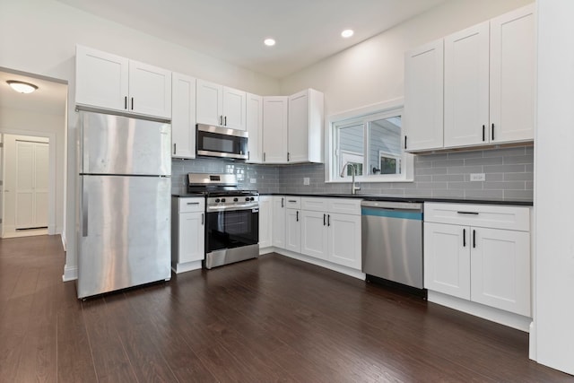 718 Sycamore St, Ottawa, IL 61350 - kitchen featuring appliances with stainless steel finishes, dark countertops, a sink, white cabinetry, and backsplash