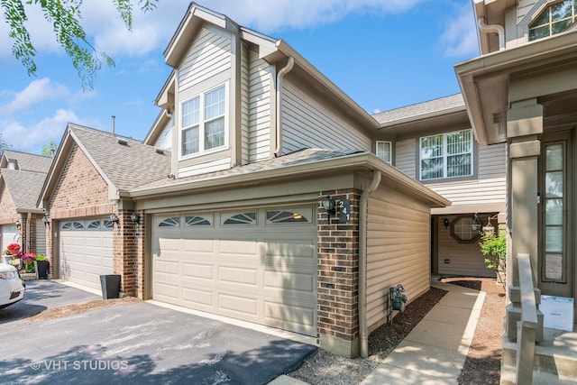 241 Old Oak Ct W, Buffalo Grove, IL 60089 - view of side of home featuring brick siding, a shingled roof, asphalt driveway, and an attached garage