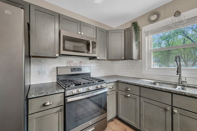710 Sunset Ln, Shorewood, IL 60404 - kitchen featuring stainless steel appliances, gray cabinetry, stone counters, and decorative backsplash