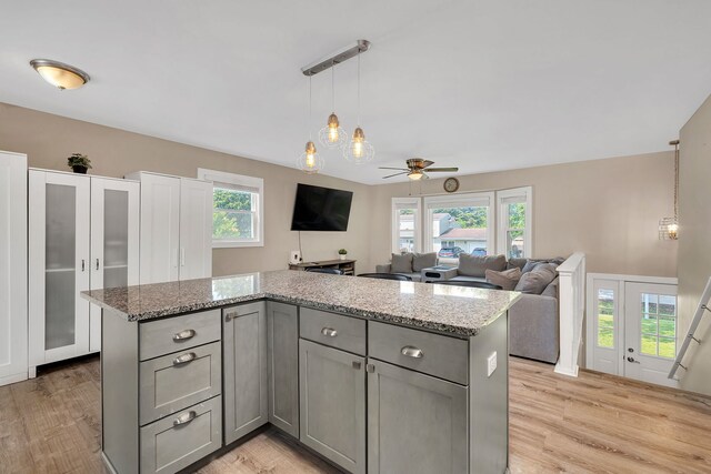 710 Sunset Ln, Shorewood, IL 60404 - kitchen with gray cabinetry, ceiling fan, light wood-style flooring, and light stone counters