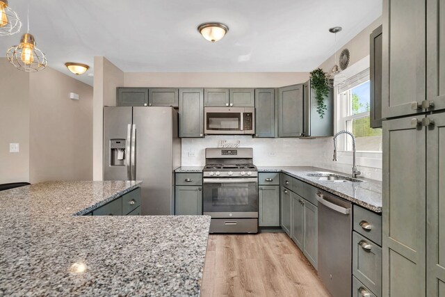 710 Sunset Ln, Shorewood, IL 60404 - kitchen featuring appliances with stainless steel finishes, light wood finished floors, light stone countertops, and tasteful backsplash