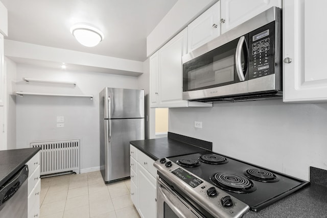 1412 Hinman Ave Unit 2W, Evanston, IL 60201 - kitchen featuring stainless steel appliances, radiator heating unit, dark countertops, and white cabinets