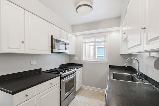 1412 Hinman Ave Unit 2W, Evanston, IL 60201 - kitchen with stainless steel appliances, white cabinets, dark countertops, and light tile patterned flooring