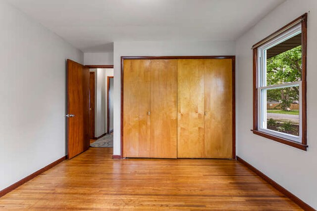307 N Carico St, Tuscola, IL 61953 - unfurnished bedroom with light wood-style floors, a closet, and baseboards