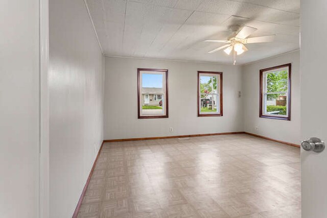 307 N Carico St, Tuscola, IL 61953 - unfurnished room with baseboards, a ceiling fan, ornamental molding, and light floors