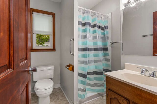 307 N Carico St, Tuscola, IL 61953 - full bathroom with toilet, vanity, a shower with shower curtain, and baseboards