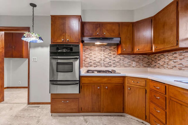 307 N Carico St, Tuscola, IL 61953 - kitchen featuring appliances with stainless steel finishes, a warming drawer, under cabinet range hood, light countertops, and decorative backsplash