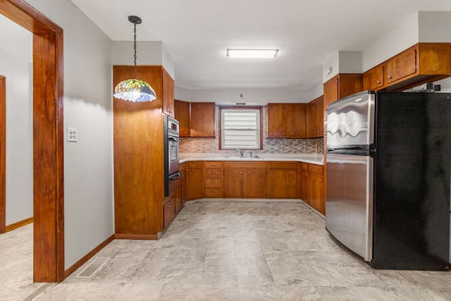 307 N Carico St, Tuscola, IL 61953 - kitchen with stainless steel appliances, brown cabinets, a sink, and light countertops