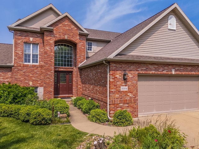 2004 Withers Ln, Bloomington, IL 61704 - traditional-style home featuring brick siding, concrete driveway, roof with shingles, and an attached garage