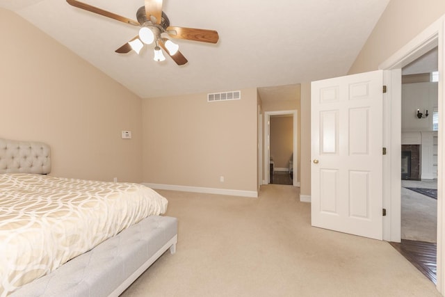2004 Withers Ln, Bloomington, IL 61704 - bedroom with light colored carpet, vaulted ceiling, a fireplace, and ceiling fan