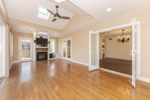 2004 Withers Ln, Bloomington, IL 61704 - unfurnished living room with light wood-style flooring, a tiled fireplace, recessed lighting, a chandelier, and vaulted ceiling