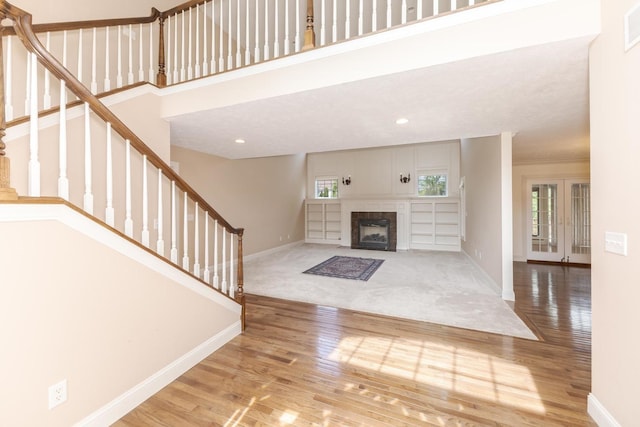 2004 Withers Ln, Bloomington, IL 61704 - unfurnished living room with wood finished floors, stairs, a fireplace with flush hearth, recessed lighting, and carpet