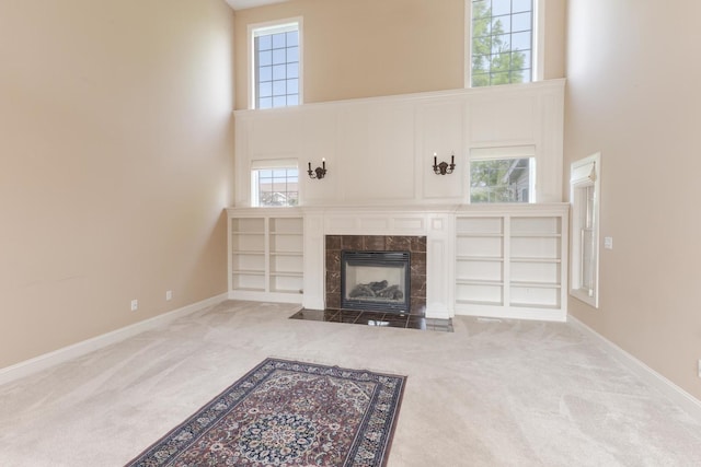 2004 Withers Ln, Bloomington, IL 61704 - unfurnished living room with a high ceiling, carpet, and a tiled fireplace