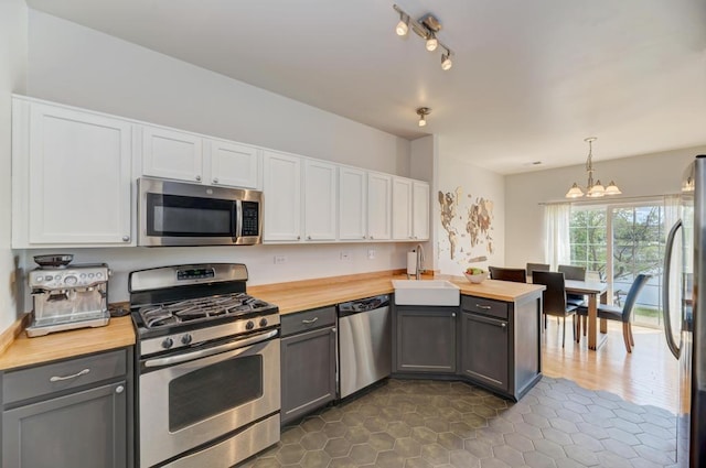 1924 Golden Gate Ln, Naperville, IL 60563 - kitchen featuring appliances with stainless steel finishes, wood counters, a sink, a chandelier, and white cabinets