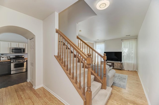 1924 Golden Gate Ln, Naperville, IL 60563 - stairs featuring hardwood / wood-style flooring, arched walkways, and baseboards