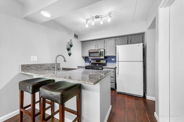 210 E Fountainview Ln Unit 2B, Lombard, IL 60148 - kitchen with stainless steel appliances, a sink, a peninsula, gray cabinetry, and a kitchen bar