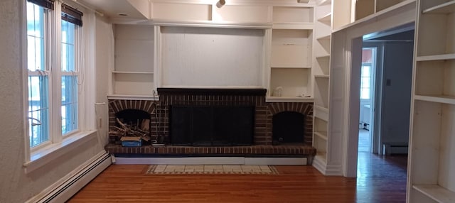 809 S Lynn St, Champaign, IL 61820 - unfurnished living room featuring a baseboard radiator, wood finished floors, a fireplace, and built in features