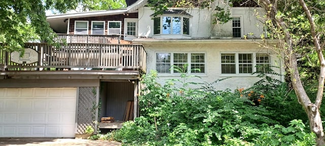 809 S Lynn St, Champaign, IL 61820 - back of property featuring stucco siding, an attached garage, driveway, and a balcony