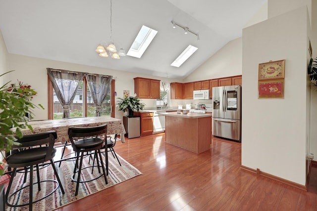 1565 Stefanie Ln, Bourbonnais, IL 60914 - kitchen featuring stainless steel fridge, white microwave, dishwashing machine, a skylight, and light countertops