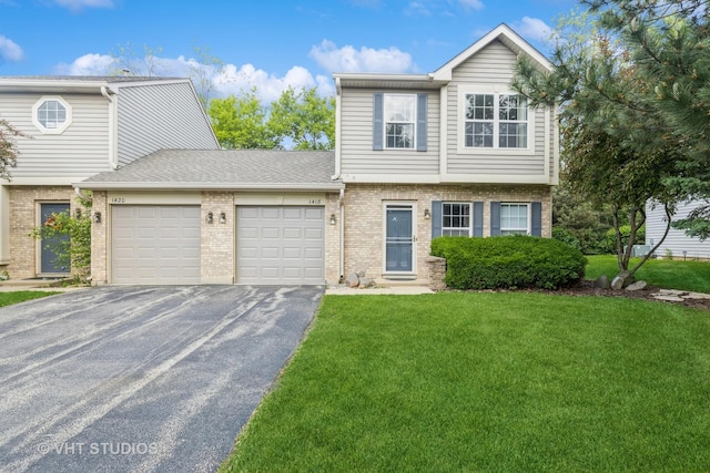 1418 W Split Oak Cir Unit 1418, Round Lake Beach, IL 60073 - colonial-style house featuring an attached garage, driveway, brick siding, and a front lawn