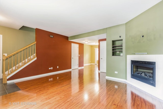 1418 W Split Oak Cir Unit 1418, Round Lake Beach, IL 60073 - unfurnished living room with wood finished floors, baseboards, stairs, and a tiled fireplace