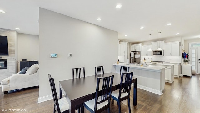 532 Ursuline Ave, Naperville, IL 60565 - dining area with dark wood-style flooring, recessed lighting, a tiled fireplace, and baseboards