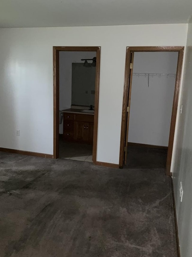 934 Evans St, Ottawa, IL 61350 - unfurnished bedroom featuring a closet, baseboards, carpet floors, connected bathroom, and a sink