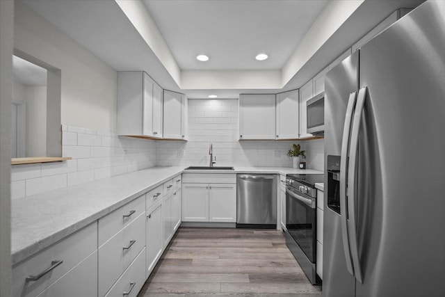 824 Mcgregor St Unit 4, Bloomington, IL 61701 - kitchen featuring stainless steel appliances, white cabinetry, light wood-style floors, recessed lighting, and tasteful backsplash