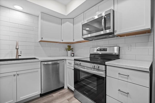 824 Mcgregor St Unit 4, Bloomington, IL 61701 - kitchen with stainless steel appliances, white cabinets, light countertops, and tasteful backsplash