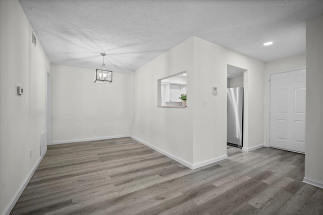 824 Mcgregor St Unit 4, Bloomington, IL 61701 - empty room featuring wood finished floors, a chandelier, a textured ceiling, and recessed lighting