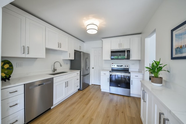 42 Plymouth Ct Unit 202B, Naperville, IL 60565 - kitchen featuring stainless steel appliances, a sink, white cabinets, light wood finished floors, and light stone counters