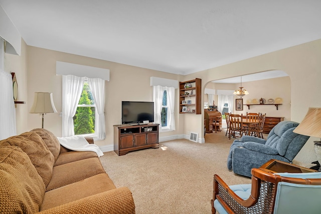 810 Glenwood Ave, Joliet, IL 60435 - carpeted living area with arched walkways, a chandelier, and baseboards