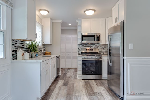 36586 N Traer Ter, Gurnee, IL 60031 - kitchen with stainless steel appliances, white cabinets, light wood-type flooring, backsplash, and ornamental molding